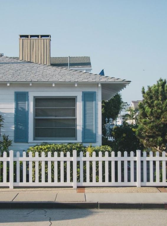 a house with a fence in front of a building