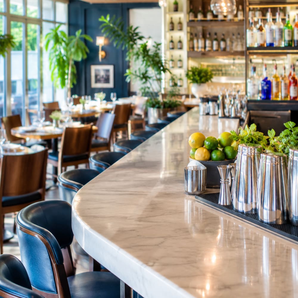 Modern restaurant and bar interior with dining tables, counter seating, and beverage displays, representing restaurant and bar insurance.